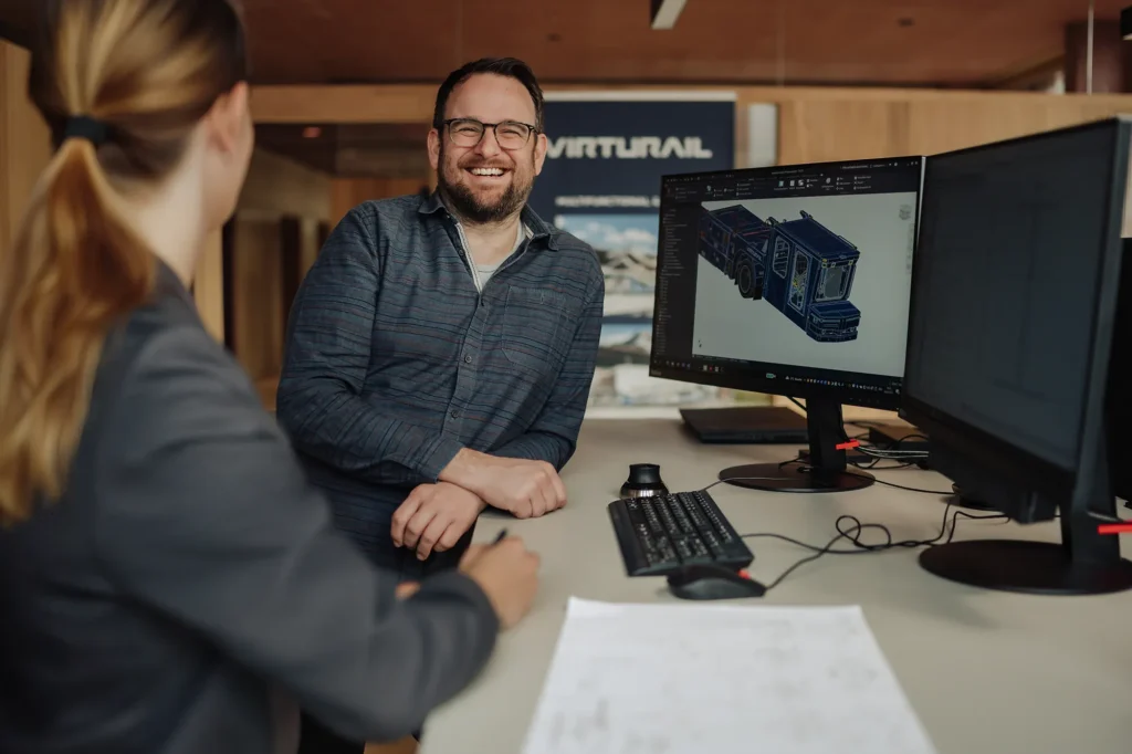 Ein Entwicklungsingenieur bespricht etwas fröhlich mit Mitarbeiterin